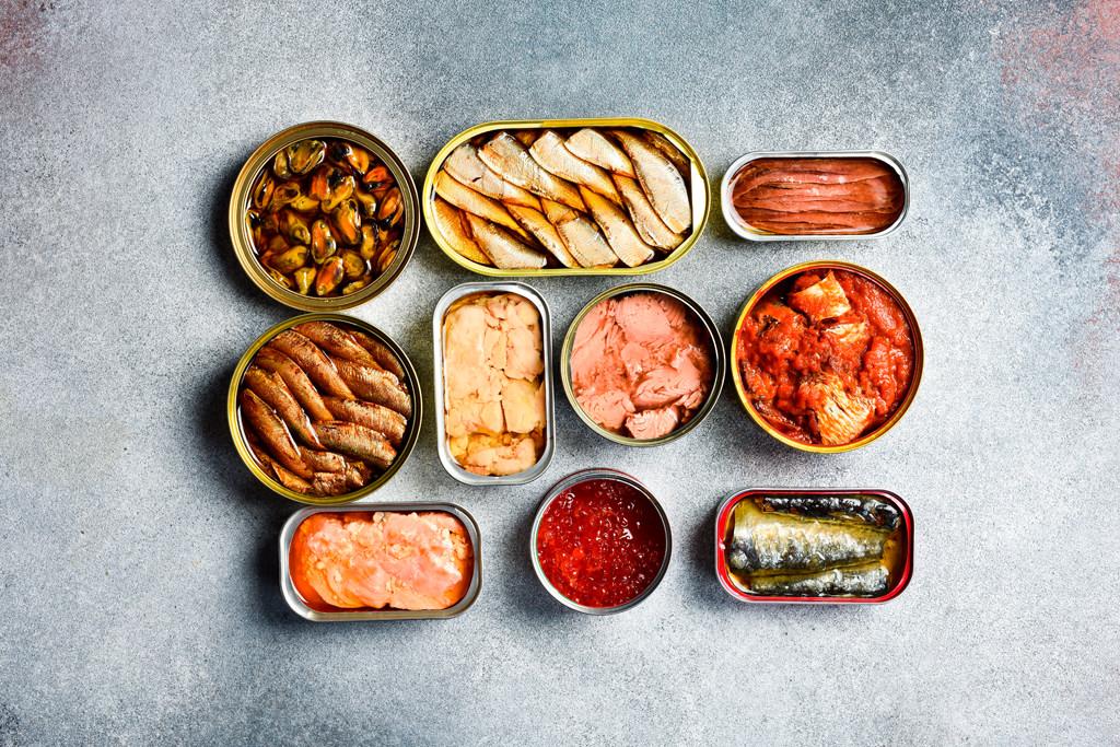 top view of canned fish and seafood: tuna, salmon roe, sprats, c
