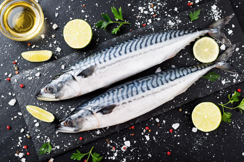 fresh fish. mackerel with salt, lemon and spices on black stone